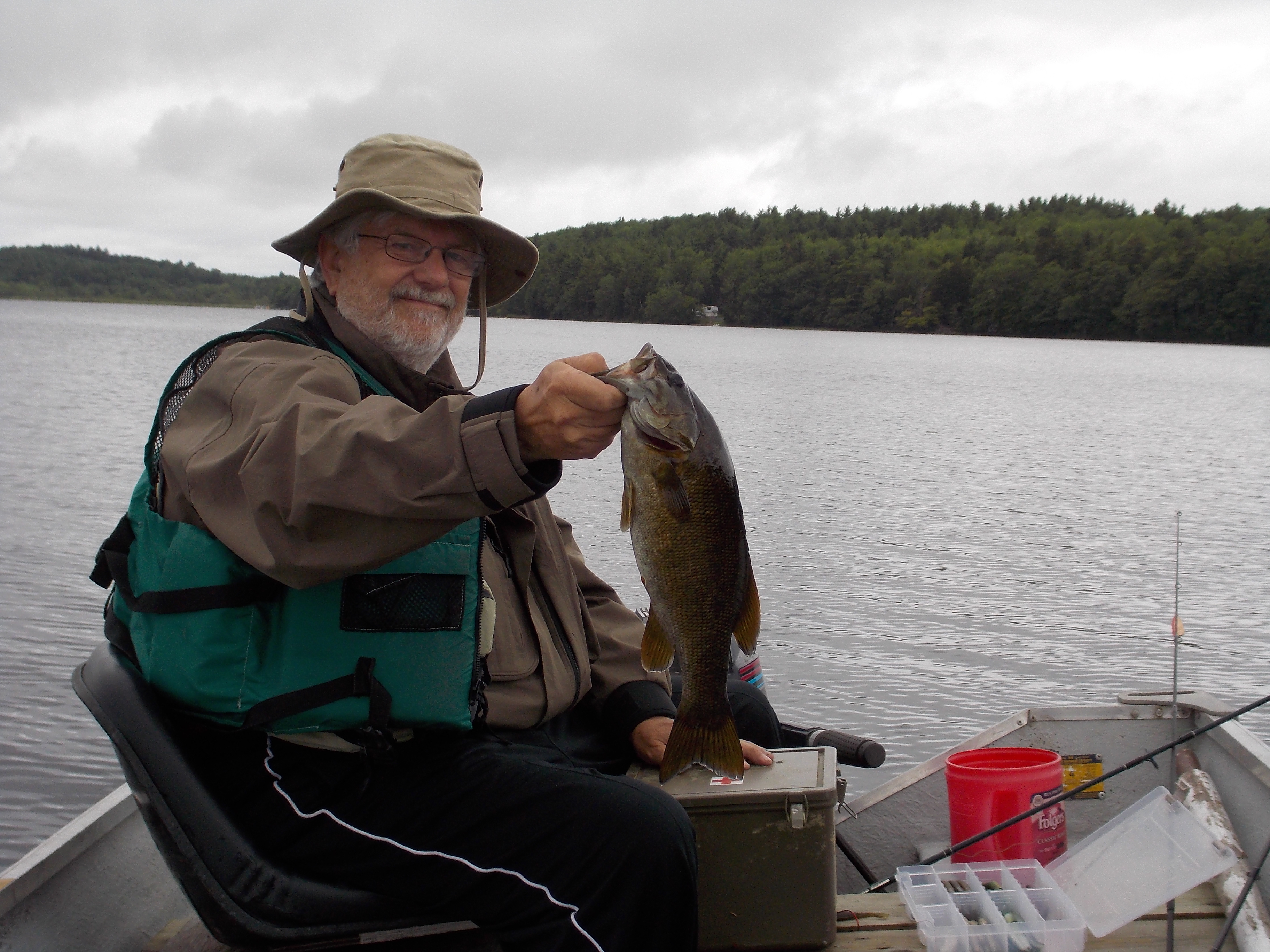 Carroll in a boat with a smallmouth bass