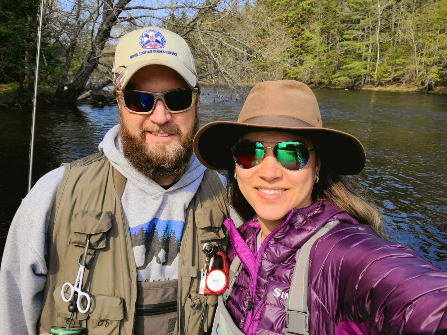 shan and sali standing in front of water wearing fishing gear